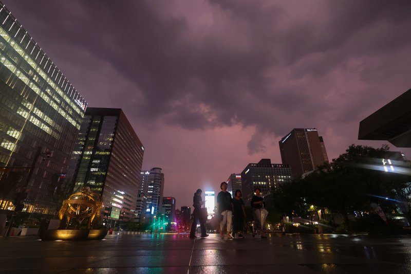 서울 최고기온이 37도까지 치솟으며 더운 날씨를 보인 8일 저녁 기습적인 폭우가 지나간 뒤 서울 종로구 광화문 광장에서 바라본 하늘이 노을로 붉게 물들어있다. 연합뉴스