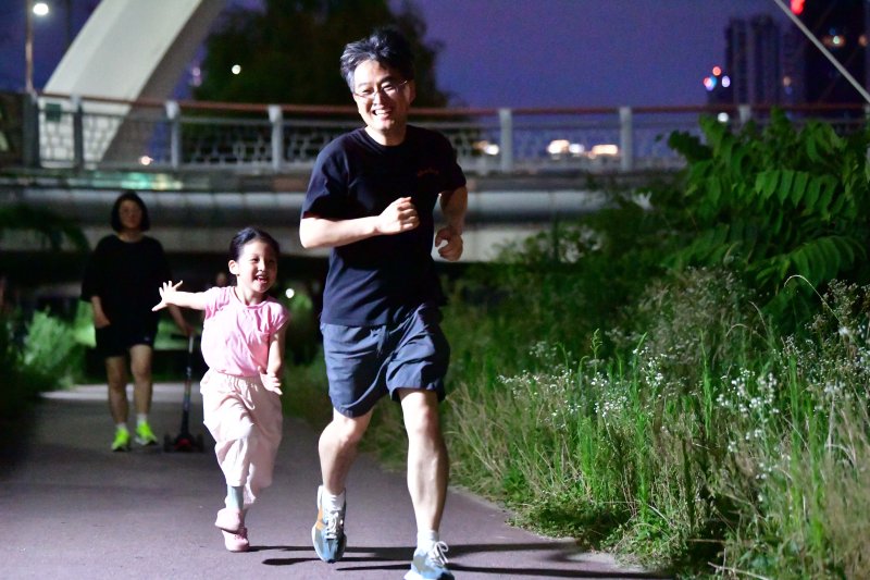 [광주=뉴시스] 이현행 기자= 8일 오후 광주 동구 광주천변 인근에서 더위를 피해 산책나온 아빠와 아이가 잡기놀이를 하고 있다. 2025.07.08 lhh@newsis.com