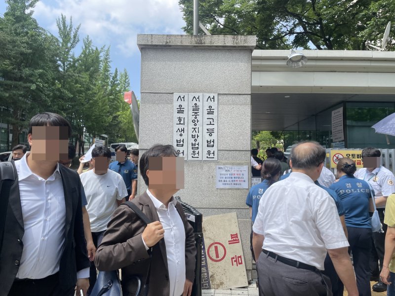 [서울=뉴시스]이채은 인턴기자=9일 오전 윤석열 전 대통령의 구속 전 피의자 심문(영장실질심사)이 열리는 서울 서초구 서울중앙지방법원 동관 입구 앞에서 시민들과 방청객들이 줄지어 출입 절차를 밟고 있다. 경찰과 법원 방호 인력이 출입을 통제하며 신분 확인과 소지품 검사를 진행하는 등 평소보다 강화된 보안 조치가 이뤄졌다.2025.07.09