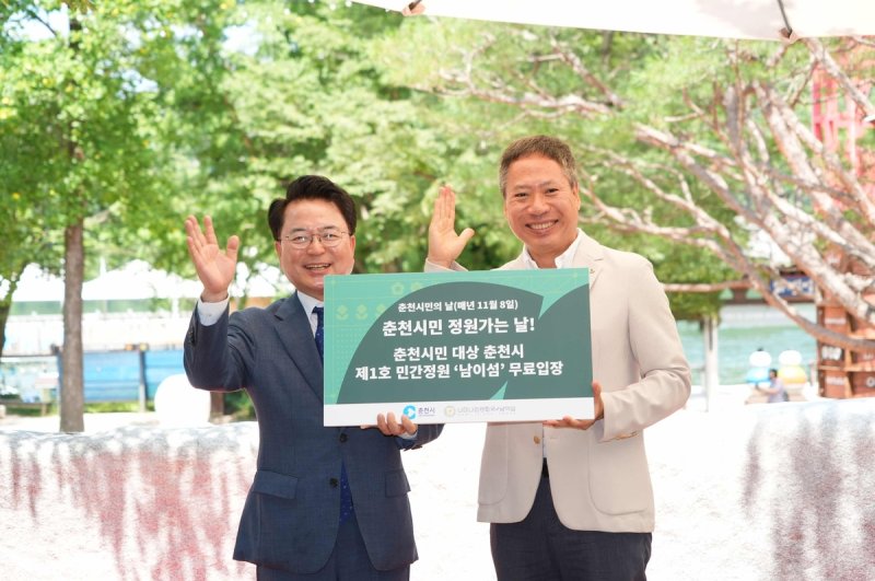 남이섬 '봄내 플라워가든' 행사장서 민 대표(오른쪽)가 육 시장에게 시민 무료입장 (출처=연합뉴스)