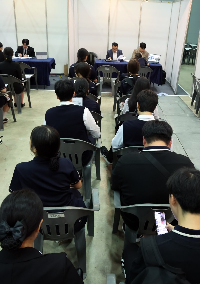 [부산=뉴시스] 하경민 기자 = '내일을 Job아 드림 페스타'(2025 부산직업교육 및 채용박람회)가 열린 9일 부산 해운대구 벡스코 제2전시장에서 학생들이 현장면접에 참여하기 위해 줄을 선 채 차례를 기다리고 있다. 오는 10일까지 이틀 간 열리는 이번 행사에서는 부산은행 등 26개 기업이 참가해 고교생들을 대상으로 현장 면접을 진행하고, 부산지역 특성화고 및 마이스터고 등 37곳이 다양한 분야의 직업교육 전시와 체험프로그램을 운영하는 한편 직업계고에 대한 현장상담을 한다. 2025.07.09. yulnetphoto@newsis