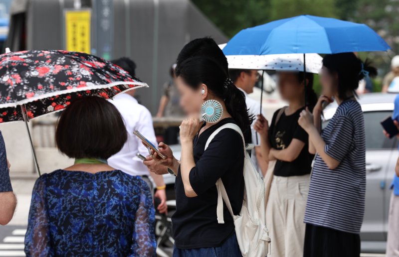 무더위가 이어지는 3일 오후 서울 도심에서 시민들이 휴대용 선풍기와 양산 등으로 저마다 더위를 식히고 있다. 2025.7.3/티파니카지노1 ⓒ News1 구윤성 기자