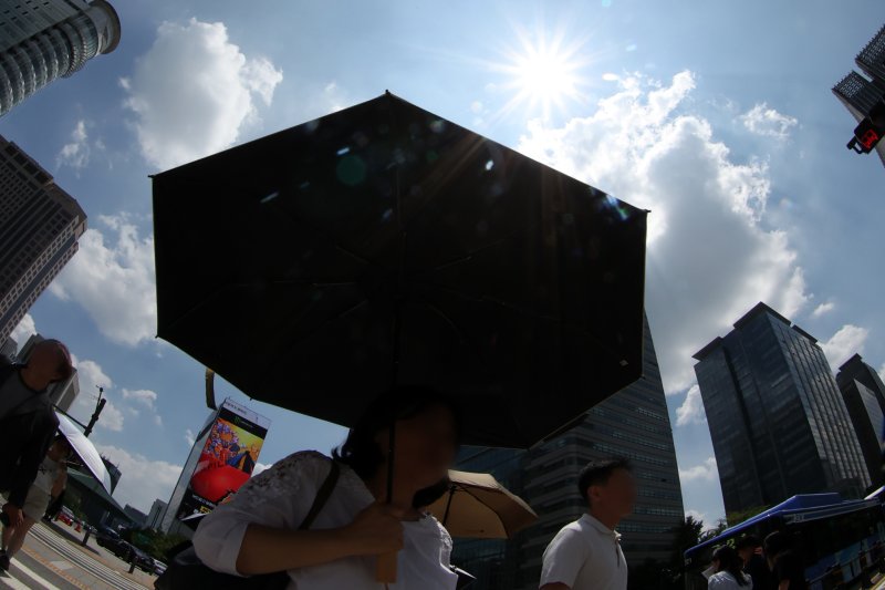 [서울=뉴시스] 조성우 기자 = 전국 대부분 지역에 폭염경보가 발효된 9일 서울 시내에서 시민이 양산을 쓰고 이동하고 있다. 2025.07.09. xconfind@newsis.com