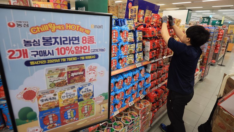 식음료 및 외식물가가 연이어 오르고 있는 가운데 정부와 식품·유통업계가 먹거리 물가 부담을 낮추기 위해 여름 휴가철에 대규모 할인 행사에 나선다고 밝혔다. 이에 따라 대형마트와 편의점들은 소비자들이 주로 찾는 라면과 빵, 커피 등을 최대 50% 저렴하게 판매한다. 사진은 서울 시내 한 대형마트 라면 판매대에서 관계자가 진열하고 있는 모습. 2025.7.7/뉴스1 ⓒ News1 김진환 기자