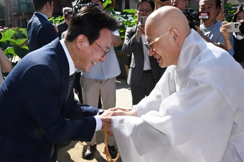 [서울=뉴시스] 청사사진기자단 = 김민석 국무총리가 10일 오전 서울 종로구 조계사 대웅전 앞에서 조계종 총무원장 진우 스님과 인사를 하고 있다. 2025.07.10. photo@newsis.com