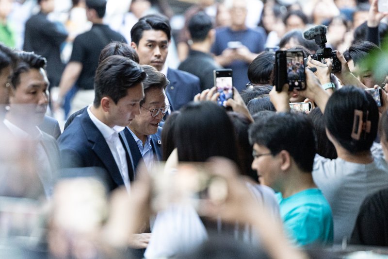 이재명 대통령이 11일 시민들과 저녁 식사를 위해 서울 종로구 광화문 인근의 한 식당으로 이동하며 시민들과 인사 나누고 있다. 2025.7.11/뉴스1 ⓒ News1 이승배 기자