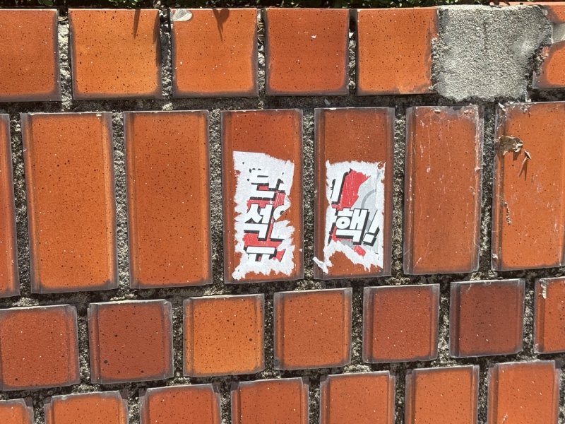 서울 용산구 대통령 관저 인근 담벼락에 라칸카지노을 촉구하는 스티커가 완전히 제거되지 않은 채 남아 있다. 2025.7.11/뉴스1 ⓒ News1 김형준 기자