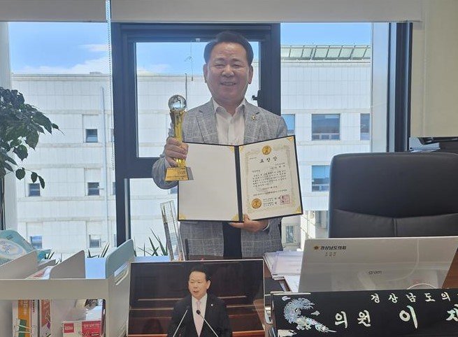 [창원=뉴시스]이재두 슈퍼스타 토토이 지난 11일 자신의 의원사무실에서 2025 대한민국 다문화예술대상 조직위원회로부터 받은 '대한민국 다문화예술대상' 의정대상 부문 표창장과 트로피를 들고 기념촬영하고 있다.(사진=이재두 도의원 제공) 2025.07.12. photo@newsis.com