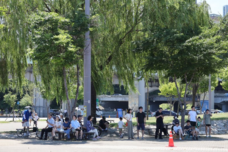 12일 오전 서울 반포한강공원에서 시민들이 공군 특수비행팀 블랙이글스의 에어쇼를 보기 위해 그늘에서 기다리고 있다. 2025.7.12/에볼루션 카지노 사이트1 ⓒ News1 신웅수 기자