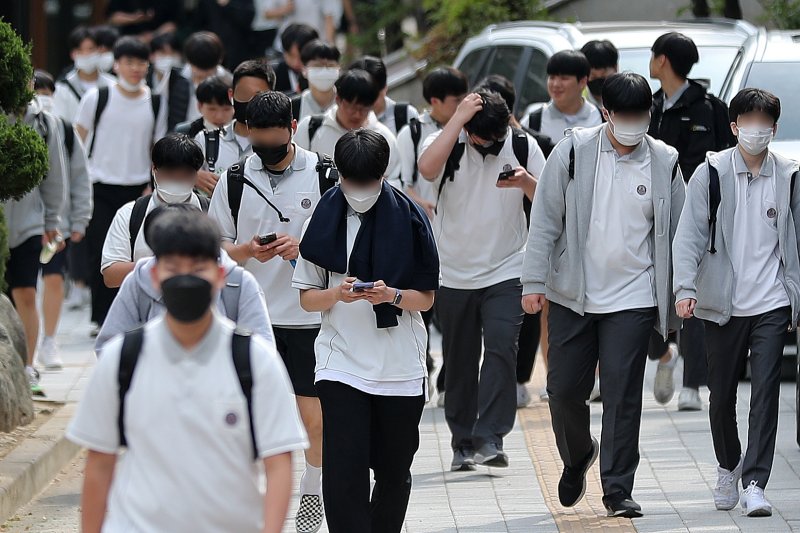 [서울=뉴시스] 백동현 기자 = 지난 2022년 5월 25일 오후 서울 시내 한 중학교 앞에서 학생들이 스마트폰을 보면서 하교하고 있다. 해당 기사와 관계없음. 2022.05.25. livertrent@newsis.com