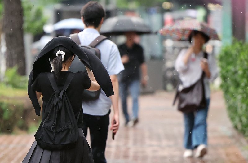 우산을 준비 못한 한 시민이 옷으로 머리를 가리며 이동하고 있다. 바카라사이트 벳무브1 ⓒ News1 김진환 기자