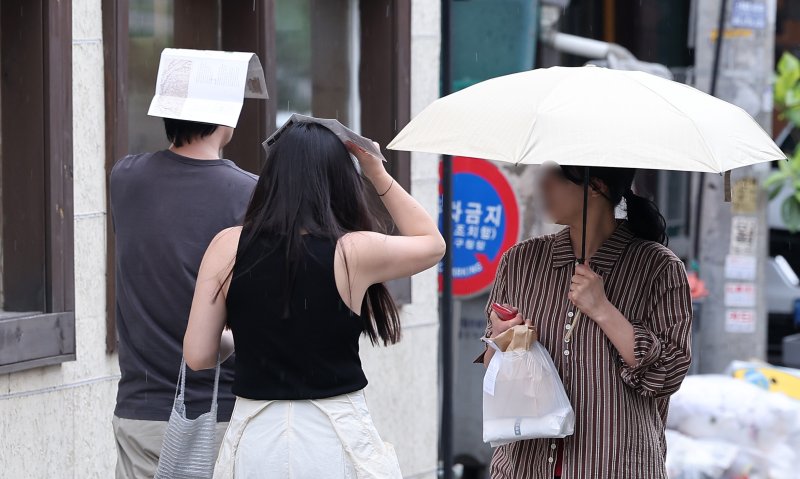 13일 서울 종로구 거리에서 시민들이 팜플렛으로 머리를 가린 채 거리를 거닐고 있다. 2025.7.13/라이브스코어 바카라사이트1 ⓒ News1 김성진 라이브스코어 바카라사이트