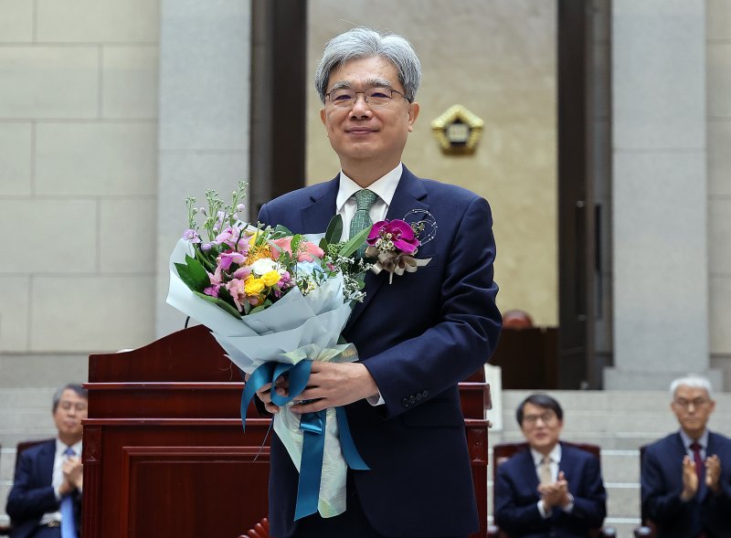 김상환 대법관이 2024년 12월 27일 오전 서울 서초구 대법원에서 열린 퇴임식에서 꽃다발을 받은 뒤 기념 촬영을 하고 있다. 이재명 대통령은 김 전 대법관을 헌법재판소장 바카라사이트 통장로 지명했다. 2024.12.27/바카라사이트 통장1 ⓒ News1 김진환 기자