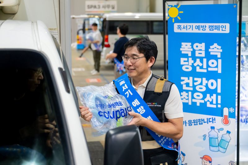 홍용준 쿠팡로지스틱스서비스(CLS) 대표이사와 위탁배송업체 대표 등이 13일 오후 서울 송파 캠프에서 퀵플렉서들에게 시원한 생수, 이온 음료, 넥쿨러, 쿨토시, 쿨패치, 스포츠캔디 등을 지급하고 있다. CLS 제공