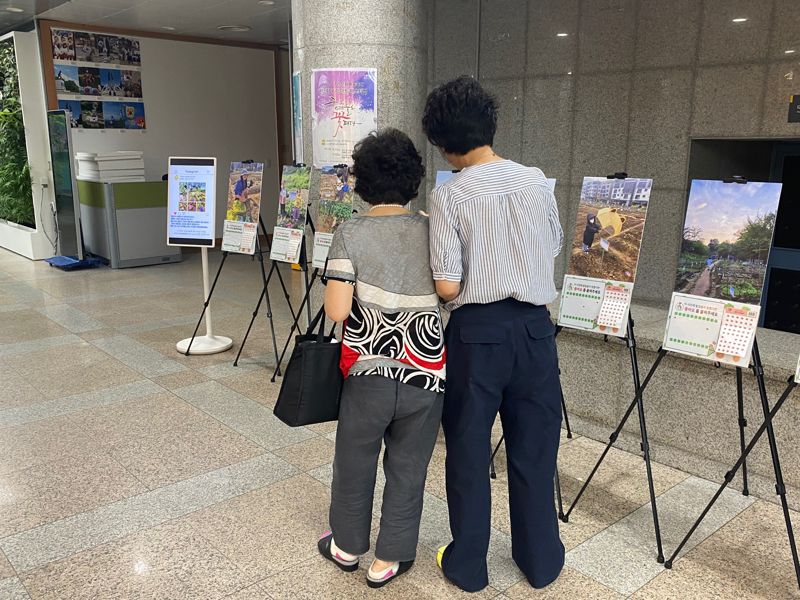 구리시가 개최한 ‘행복 팜팜' 텃밭 사진 전시회에서 시민들이 작품을 둘러보고 있다. 구리시 제공