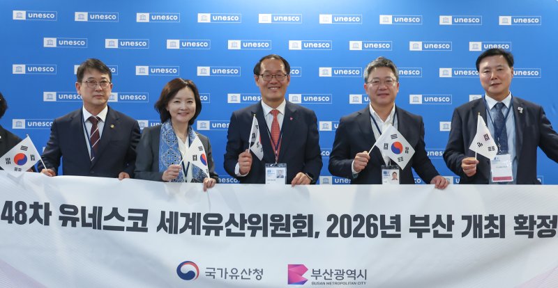 2026년 세계유산위원회 개최지로 부산이 확정된 16일 새벽(한국시간) 프랑스 파리 유네스코 본부에서 최응천 국가유산청장(왼쪽부터)과 박상미 주유네스코 대표부 대사, 이준승 부산시 행정부시장, 국민의힘 박정하 의원, 더불어민주당 조계원 의원이 플래카드를 들고 기념 촬영을 하고 있다. 뉴스1