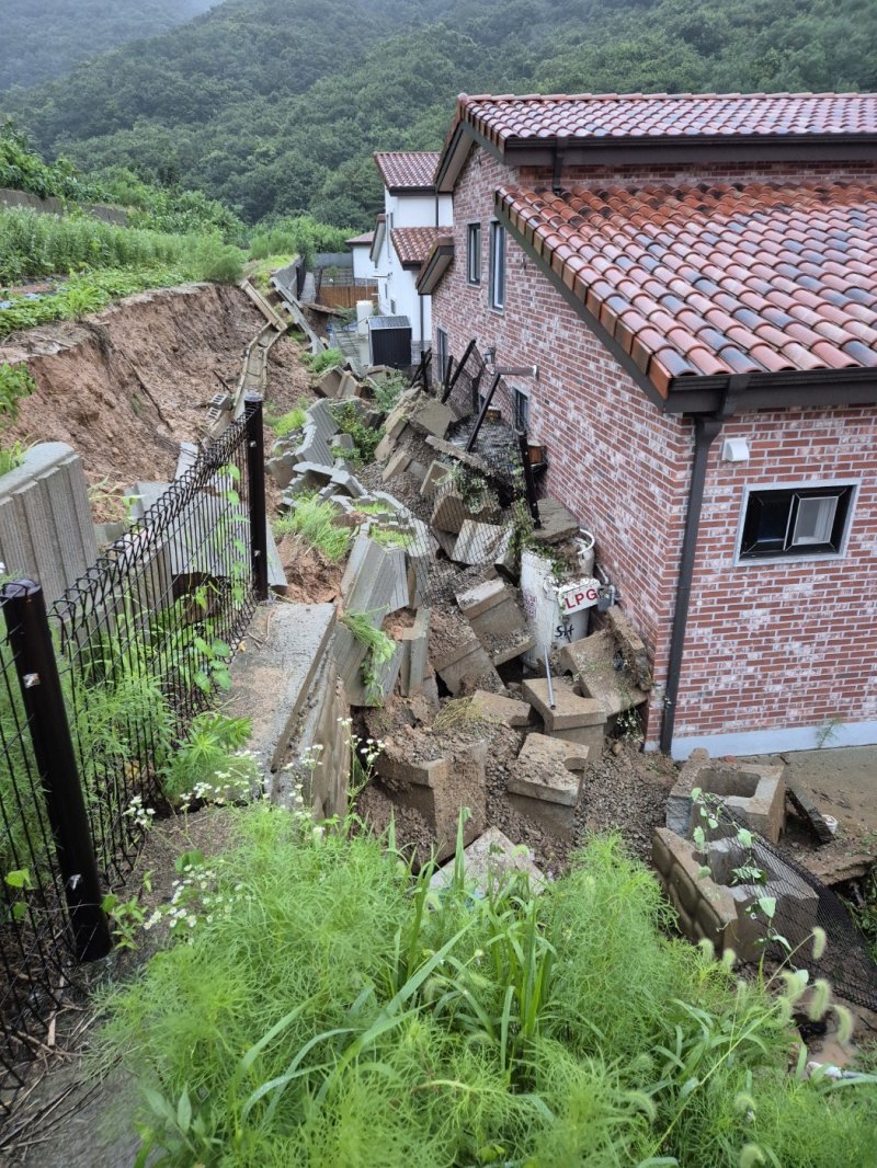 [음성=뉴시스] 17일 오전 5시56분께 충북 음성군 음성읍의 한 주택 뒷마당에서 빗물에 무너진 옹벽이 200㎏짜리 LPG통을 덮쳤다. 가스가 소량 누출됐으나 긴급 안전조치로 추가 피해는 발생하지 않았다. (사진=충북소방본부 제공) 2025.07.17. photo@newsis.com