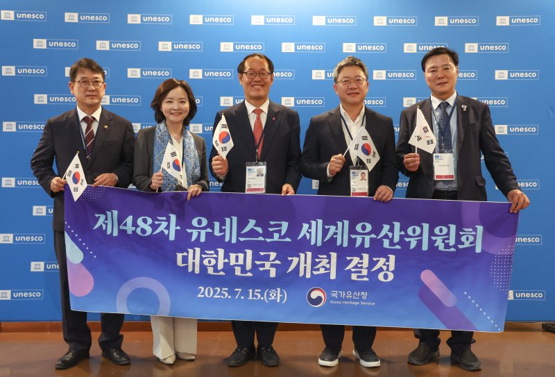 2026년 세계유산위원회 개최지로 부산이 확정된 16일 새벽(한국시간) 프랑스 파리 유네스코 본부에서 최응천 국가유산청장(왼쪽부터)과 박상미 주유네스코 대표부 대사, 이준승 부산시 행정부시장, 국민의힘 박정하 의원, 더불어민주당 조계원 의원이 플래카드를 들고 기념 촬영을 하고 있다. 2025.7.16/뉴스1 ⓒ News1 이준성 기자