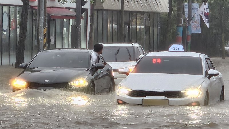 [광주=뉴시스] 이영주 기자 = 광주지역에 시간당 86㎜ 폭우가 쏟아진 17일 오후 광주 북구청 앞 교차로에서 차량들이 폭우로 넘치는 빗물에 갇혀 오가지 못하고 있다. 2025.07.17. leeyj2578@newsis.com