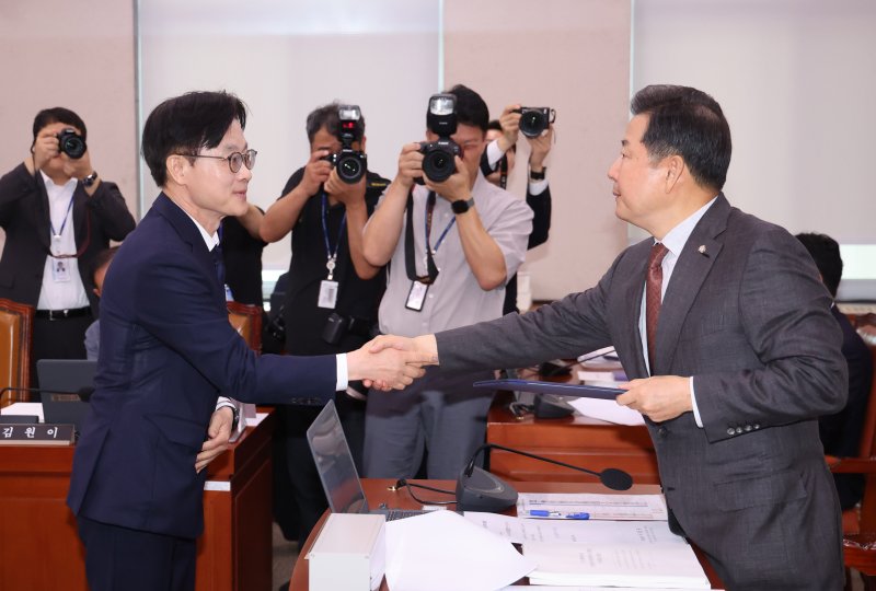 [서울=뉴시스] 김명년 기자 = 김정관 산업통상자원부 장관 후보자가 17일 오전 서울 여의도 국회 산업통상자원중소벤처기업위원회에서 열린 인사청문회에서 이철규 위원장에게 선서문을 전달한 뒤 악수하고 있다. 2025.07.17. kmn@newsis.com