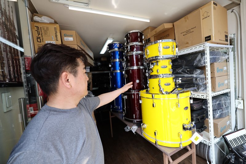 18일 광주 북구 용봉동동 전남대 후문 일대가 전날 내린 폭우로 침수돼 한 악기상가의 상인이 물에 젖은 드럼통을 대피시키고 있다. 2025.7.18/뉴스1 ⓒ News1 박지현 기자