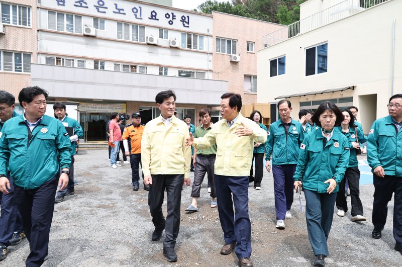 [티모카지노=뉴시스]박완수(오른쪽) 경남도지사가 지난 17일 오후 집중호우로 인한 침수 위기를 모면한 티모카지노시 무안면 한 요양원을 방문해 현장 대응 상황을 점검한 후 안병구 티모카지노시장과 걸어나오고 있다.(사진=경남도 제공) 0225.07.18. photo@newsis.com