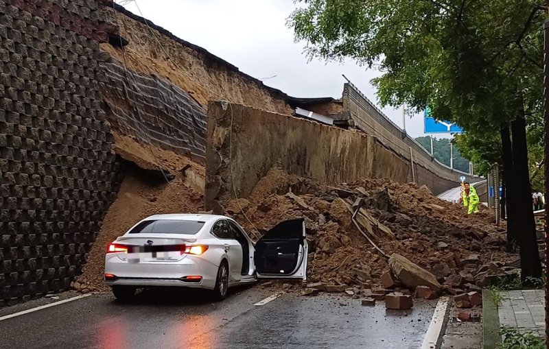 [오산=뉴시스] 김종택 기자 = 수도권 등 중부지역에 호우주의보가 발효된 16일 경기 오산시 가장교차로 옹벽이 도로로 무너져 차량을 덮치는 사고가 발생해 소방 당국이 대응 1단계를 발령, 구조작업을 벌이고 있다. (사진=경기도소방재난본부 제공) 2025.07.16. photo@newsis.com