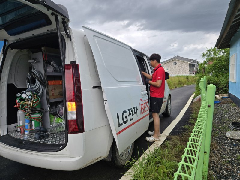 지난 19일 충남 예산군 수해 현장에 파견된 LG전자 서비스 매니저가 차에서 물건을 꺼내고 있다. LG전자 제공