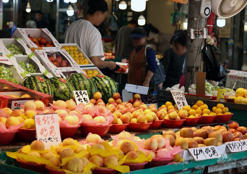 21일 서울의 한 전통시장에서 시민들이 장을 보고 있다. 역대급 폭우에 쌀, 수박, 고추, 깻잎 등 주요 농산물과 축산 농가가 일제히 침수 피해를 입었다. 전국적으로 서울 면적의 약 40%에 달하는 규모의 농작물이 물에 잠긴 것으로 나타났다. 이에 따라 막대한 농가 피해는 물론, 밥상물가 상승 우려도 커지고 있다. 2025.7.21/뉴스1 ⓒ News1 구윤성 기자