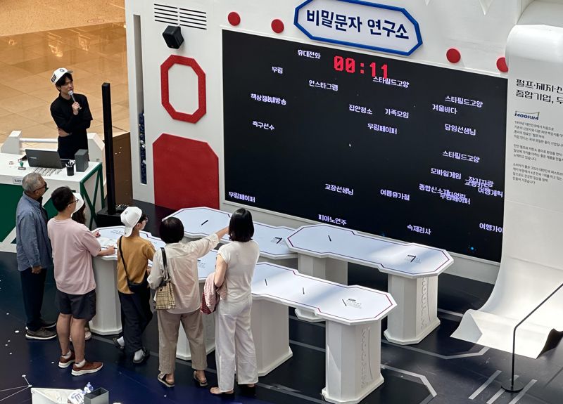 22일 스타필드 고양점에서 열린 '무림 페이퍼어드벤처'에서 '비밀 암호풀기' 체험을 하는 관람객들. 사진=서지윤 기자