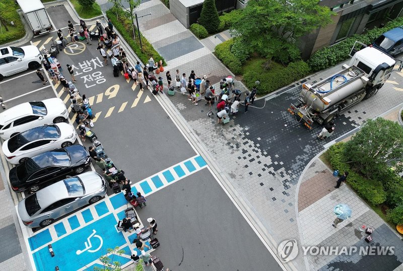 줄 서서 물 받는 아파트 주민들 (출처=연합뉴스)