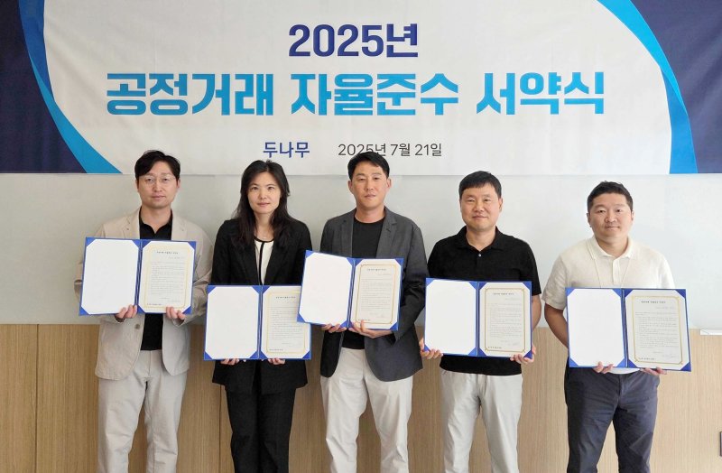 두나무 오경석 대표(CEO)가 지난 21일 서울 스퀘어큐브에서 열린 공정거래 자율준수 서약식에서 기념촬영을 하고 있다. 왼쪽부터 두나무 임종헌 CLO, 윤선주CBIO, 오 대표, 남승현 CFO, 정재용 CISO 두나무 제공