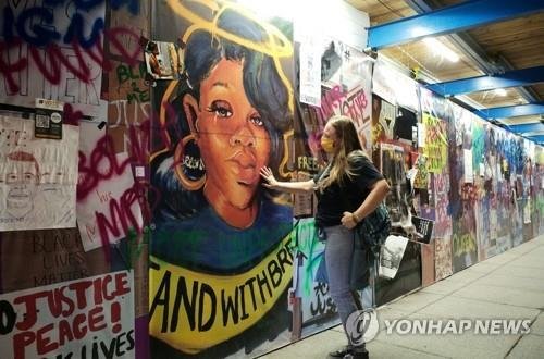 경찰 총기 피격 사망' 테일러 얼굴 벽화 어루만지는 미 여성 (출처=연합뉴스)