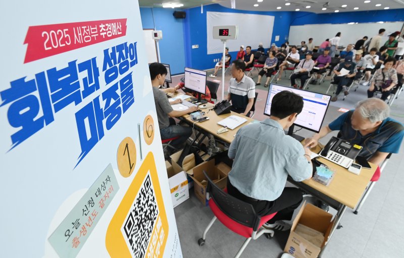 [수원=뉴시스] 김종택 기자 = 정부의 민생회복 소비쿠폰 1차 신청 첫날인 지난 21일 경기 수원시 인계동 행정복지센터에서 시민들이 지원금을 신청하고 있다. 2025.07.21. jtk@newsis.com