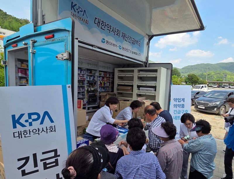 동아제약 임직원들이 봉사약국 트럭에서 의약품을 전달하고 있다. 동아제약 제공