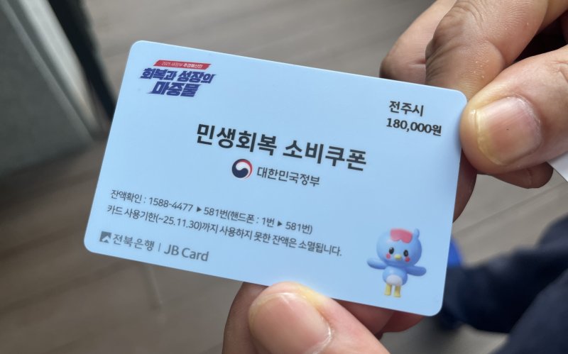 [전주=뉴시스] 강경호 기자 = '민생회복 소비쿠폰'의 1차 신청이 시작된 21일 전북 전주시 완산구 서신동주민센터에서 소비쿠폰 실물 선불카드를 발급받은 시민이 내민 실물카드의 모습. 2025.07.21. lukekang@newsis.com