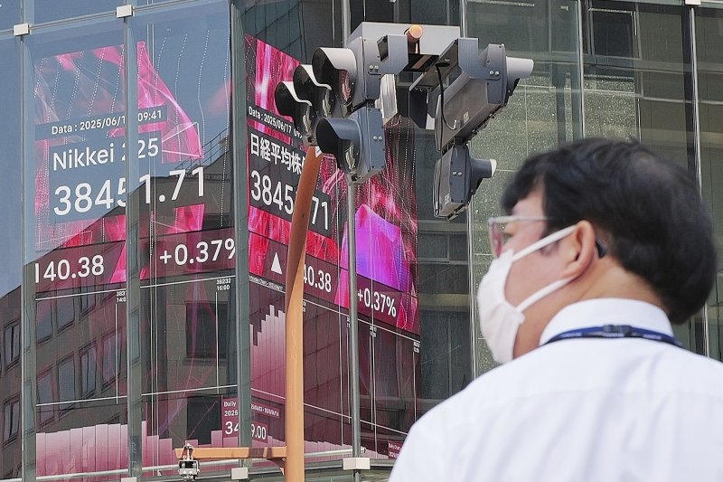 [도쿄=AP/뉴시스] 23일 일본 도쿄증시에서 닛케이255지수(닛케이평균주가)가 미일 무역합의 체결 소식에 800 포인트 이상 상승해 4만선을 돌파했다. 지난 17일 일본 도쿄의 한 증권사 전광판 앞을 시민이 지나하고 있다. 2025.07.23.