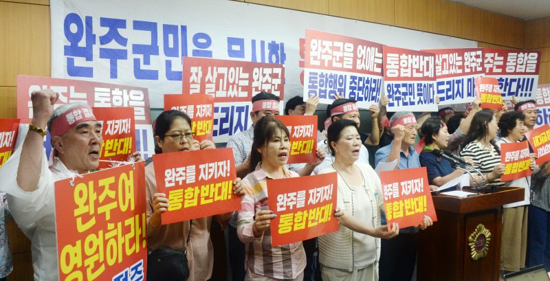[전주=뉴시스] 김얼 기자 = 완주-전주통합반대 완주군민대책위원회 관계자들이 23일 전북 전주시 전북특별자치도의회 기자회견장에서 완주-전주 통합행위 즉각 중단 기자회견을 열고 구호를 외치고 있다. 2025.07.23. pmkeul@newsis.com