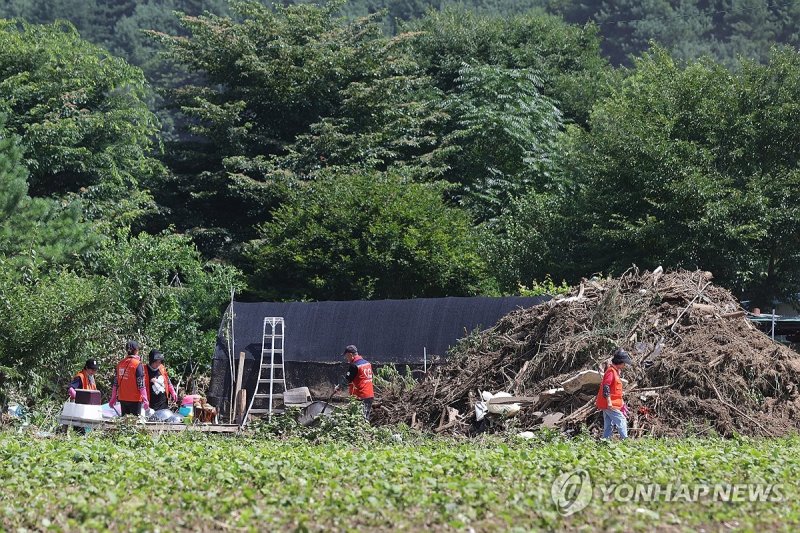 수해 복구 돕는 자원봉사자들 (출처=연합뉴스)