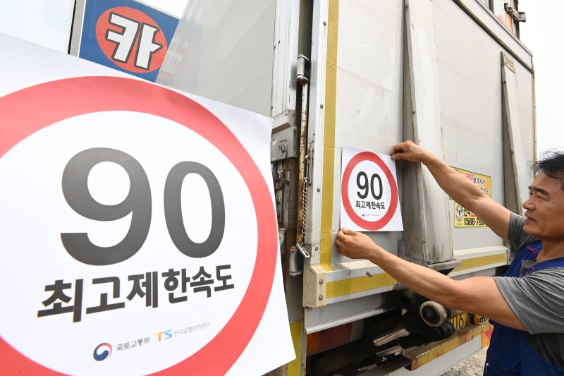 [화성=뉴시스] 김종택 기자 = 23일 경기 화성시 한 화물차 운행기록장치(DTG)점검센터에서 관계자가 화물차 후면에 최고 제한속도 스티커를 부착하고 있다. 국토교통부와 한국교통안전공단(TS)은 오늘부터 총중량 3.5t(톤)을 초과하는 화물차를 대상으로 ‘최고 제한속도(90㎞/h) 스티커’를 부착하는 시범사업을 실시했다. 2025.07.23. jtk@newsis.com