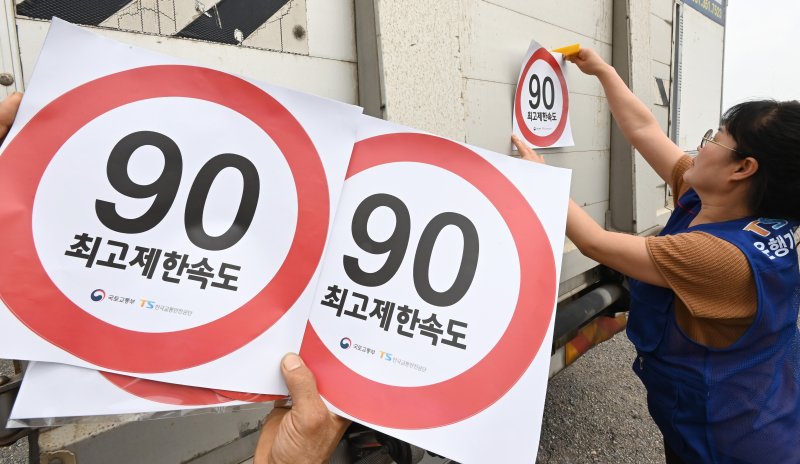 [화성=뉴시스] 김종택 기자 = 23일 경기 화성시 한 화물차 운행기록장치(DTG)점검센터에서 관계자들이 화물차 후면에 최고 제한속도 스티커를 부착하고 있다. 국토교통부와 한국교통안전공단(TS)은 오늘부터 총중량 3.5t(톤)을 초과하는 화물차를 대상으로 ‘최고 제한속도(90㎞/h) 스티커’를 부착하는 시범사업을 실시했다. 2025.07.23. jtk@newsis.com