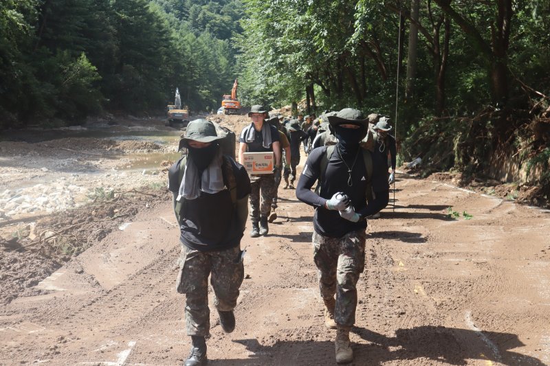 23일 경기 가평 일대에서 수기사 장병들이 고립지역 주민들을 위해 구호물자를 도수 운반하고 있다. 육군 제공