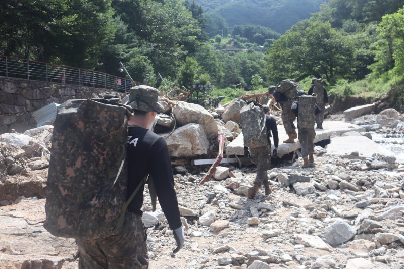 23일 경기 가평 일대에서 수기사 장병들이 고립지역 주민들을 위해 구호물자를 도수 운반하고 있다. 육군 제공