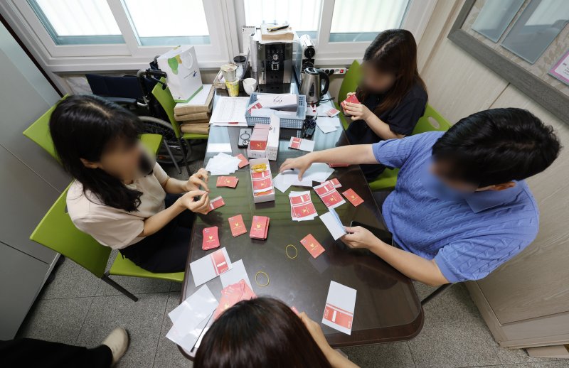 광주시가 민생 회복 소비쿠폰 선불카드의 액수별 '카드 색상'을 다르게 배부해 논란이 인 가운데 24일 광주 한 행정복지센터에서 공직자들이 선불카드에 스티커 부착 작업을 하고있다. 2025.7.24/뉴스1 ⓒ News1 김태성 기자