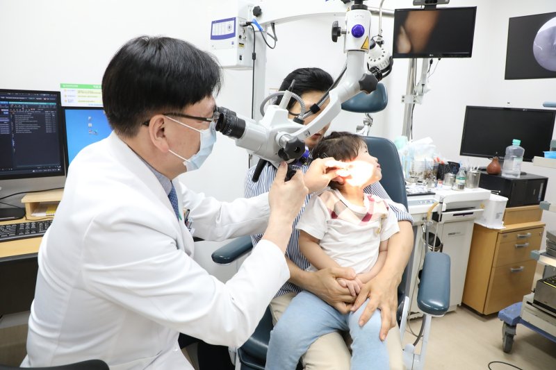 [광주=뉴시스] 전남대학교병원은 병원과 KT가 함께 한 지원사업을 통해 선천성 난청 환자인 2세 아동에게 인공와우(청력 보조 의료기기) 이식 수술을 성공적으로 마쳤다고 24일 밝혔다. 사진은 병원 이비인후과 조형호 교수가 난청 아동을 진료하는 모습. (사진=전남대병원 제공) 2025.07.24. photo@newsis.com *재판매 및 DB 금지