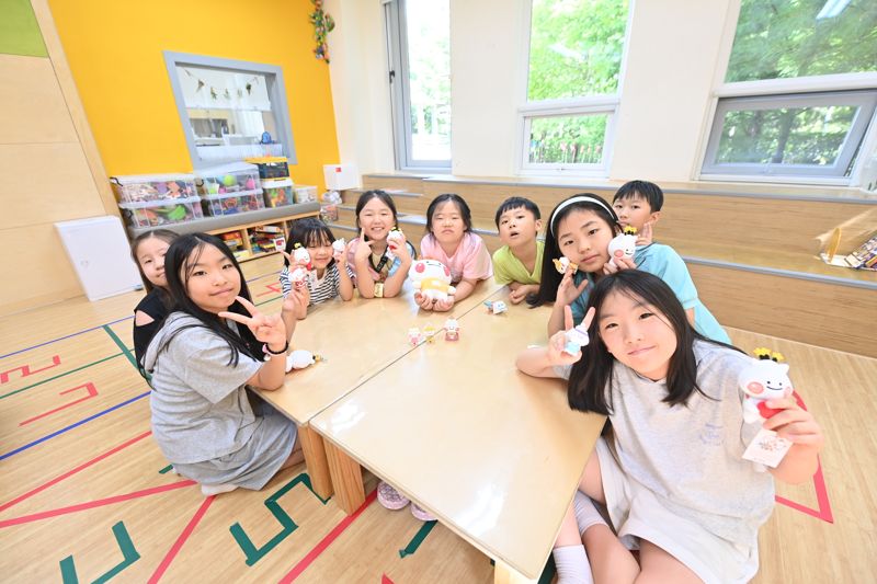 아이들이 청정하남 소식지의 부록인 하남이·방울이 캐릭터 ‘페이퍼 토이’를 들고 환하게 웃고 있다. 하남시 제공