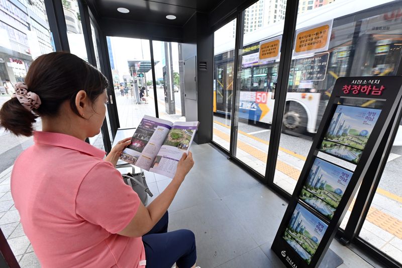 미사역 인근 스마트쉘터 버스정류소에서 한 시민이 ‘청정하남’ 소식지를 읽으며 버스를 기다리고 있다. 하남시 제공