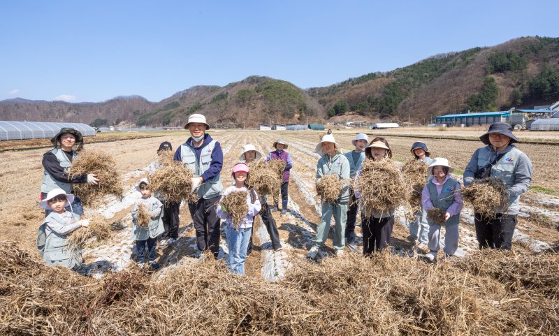 대한항공·아시아나항공 양사 임직원과 가족들이 지난 4월 강원도 홍천군 명동리 1사1촌 자매결연 마을에서 농가 일손을 돕고 있다. 대한항공 제공