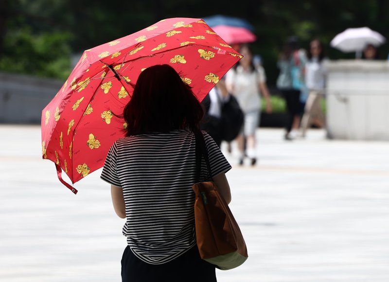 서울 전역에 폭염경보가 내려진 24일 서울 용산구 국립중앙박물관에서 시민들이 양산을 쓰고 뜨거운 햇빛을 가리고 있다. 2025.7.24/뉴스1 ⓒ News1 김민지 기자
