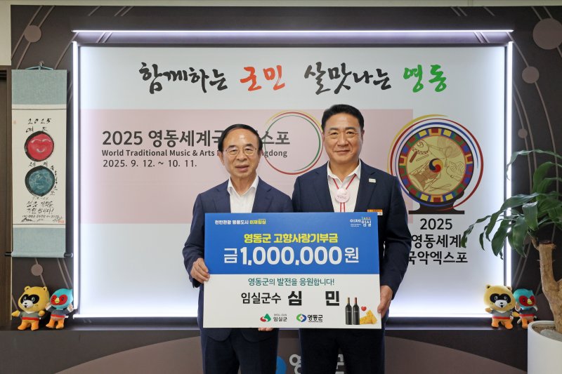 심민 전북 임실군수(왼쪽)가 정영철 충북 영동군수에게 고향사랑기부금 100만원을 기탁하고 있다.(임실군제공. 재판매 및 DB금지)2025.7.25/뉴스1